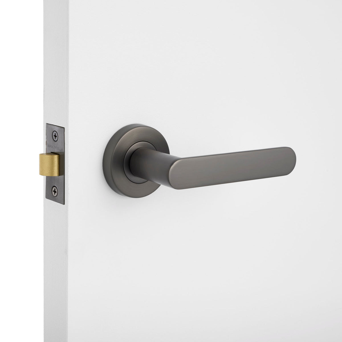 Modern door handle on a white door with a light gray background