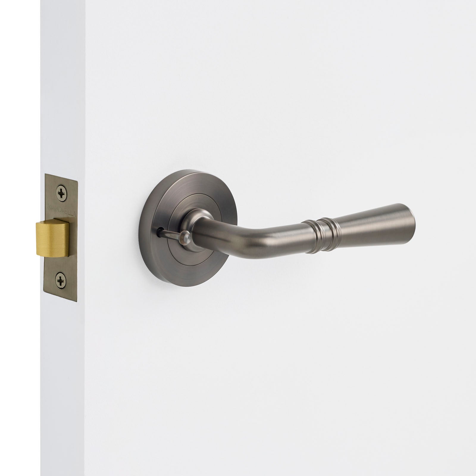 Gunmetal door handle on a white door with a visible lock mechanism.