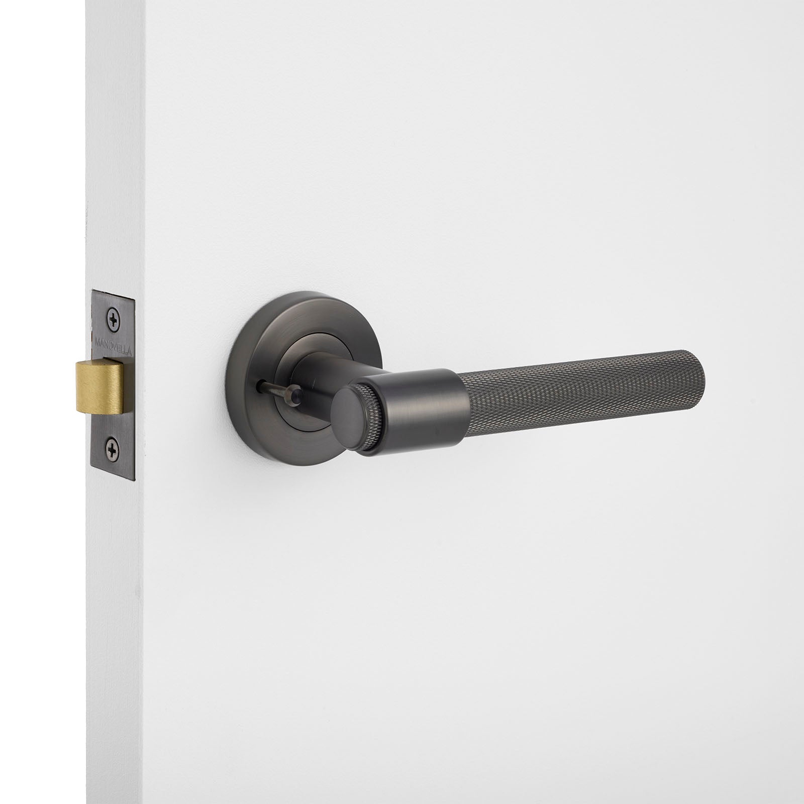 Gunmetal knurled privacydoor handle on a white door with a gold latch.